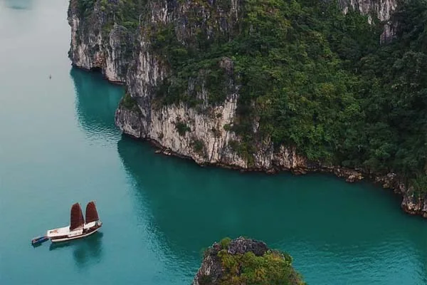 una giunca si avvicina ad una parete rocciosa, Baia di Ha Long